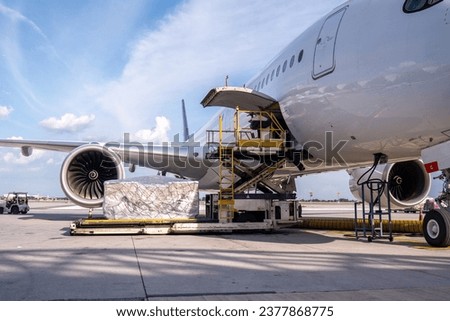 Air cargo logistic containers are loading to an airplane. Air transport shipment prepare for loading to modern freighter jet aircraft at the airport. Royalty-Free Stock Photo #2377868775