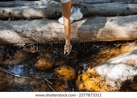 Man reaching out with his hand to the water in the stream, refreshing cool water in the river, drinking from the river, dipping his hand in the water, mountain stream. High quality photo