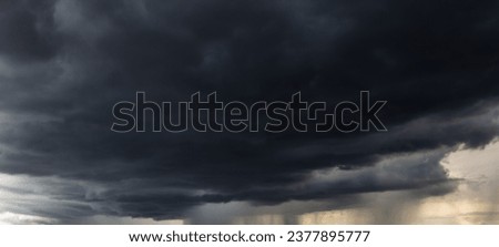 The dark sky with heavy clouds converging and a violent storm before the rain.Bad or moody weather sky and environment. carbon dioxide emissions, greenhouse effect, global warming, climate change