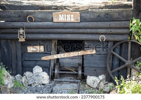 gold Rush with rusty wagon in the old abandoned golden mine in the old west with wooden panel text sign danger keep out