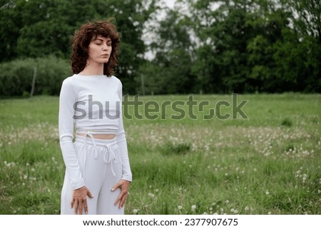 Sportswoman closed her eyes to focus on breathing fresh air. Woman doing meditation technique for relax mind. Female yoga instructor showing pranayama practice on park background