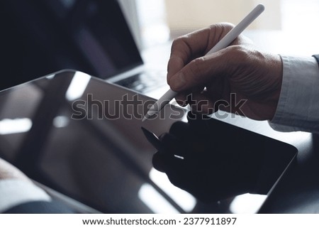 Close up, businessman using stylus pen signing e-document on digital tablet at office, E-signing, electronic signature concept. Business man online working on computer devices on office desk