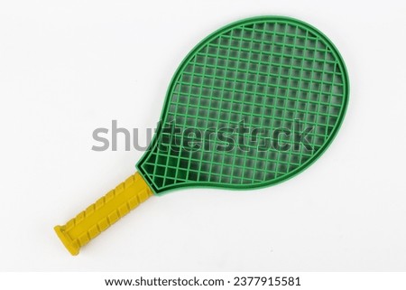 Green tennis racket with yellow handlefor children isolated white background