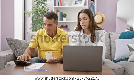 Father and daughter bonding over family accounting session on the sofa at home