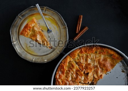Filo pastry pie with one slice on a plate, mine meat Greek pie top view, mediterranean food picture