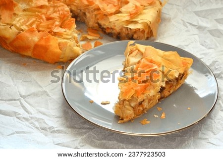 Filo pastry pie with one slice on a plate, potato sun dried tomao Greek pie top view, mediterranean food picture
