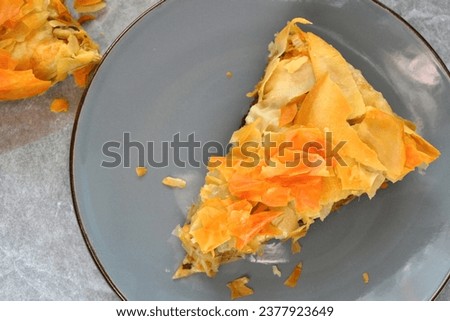 Filo pastry pie with one slice on a plate, zucchini Greek pie top view, mediterranean food picture