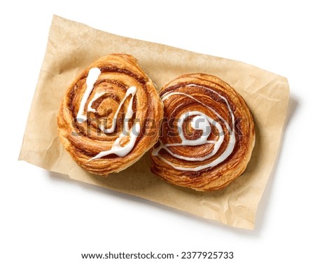 freshly baked cinnamon rolls isolated on white background, top view Royalty-Free Stock Photo #2377925733