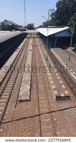 The train is running on the railroad tracks. The picture of the train tracks was taken from the view above the bridge at Gubeng Surabaya station 