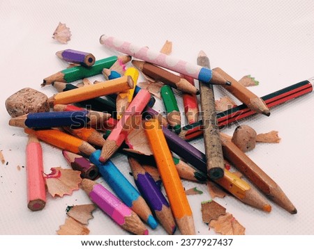Crayons of various colors lying on a white floor that have long since expired cannot be used again as intended. Colored pencils are a drawing tool for children's art and learning. Royalty-Free Stock Photo #2377927437