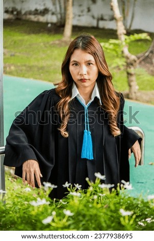 Woman wearing a graduation gown taking pictures on graduation day