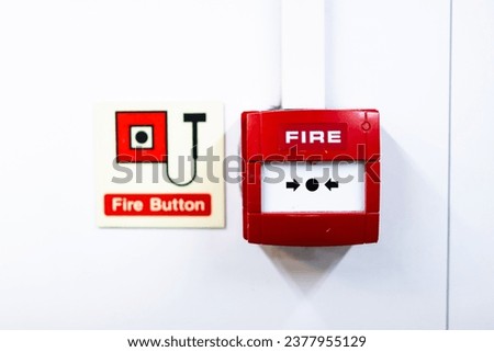 Red fire alarm button with its respective warning sign on the back.