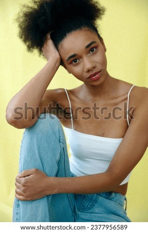Young beautiful girl over yellow background in studio.	
