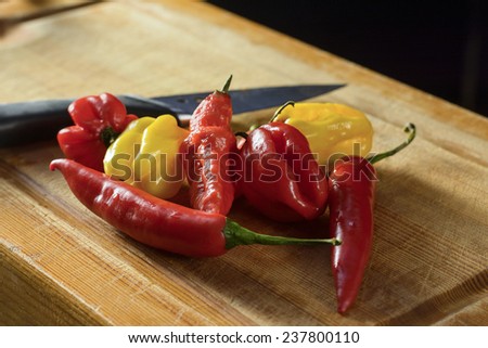 bunch of chilies on a cutting board. Bhut, habanero, red, yellow chilies