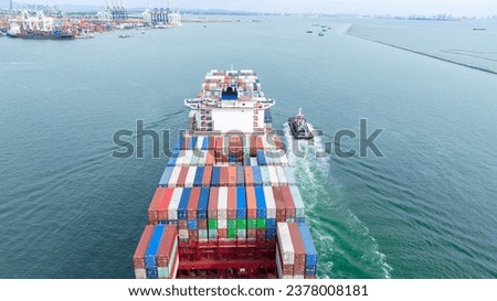 Cargo container ship carrying container and running with tug boat for import goods to cargo yard port to customs. concept logistics transportation and shipping.

