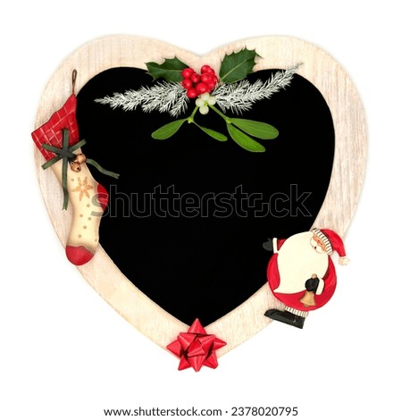 Christmas heart shape wreath with stocking, santa retro decorations and winter greenery. Traditional romantic symbols for holiday season on white with chalkboard. 