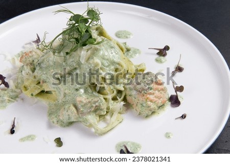 Pasta with salmon in a plate. On a dark background. Selective focus.
