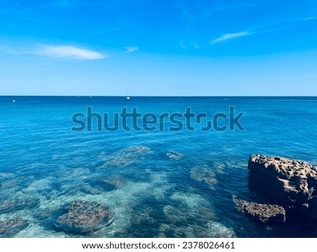 Azure sea surface, transparent sea water, rocky coast, ocean bay