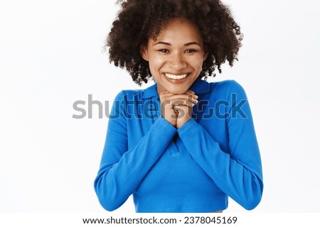 Portrait of young african american woman, gazing with love and care, admire smething, anticipating with excitement, standing over white background.