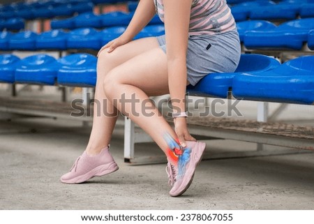 Plantar fasciitis, heel spur, joint inflammation, foot pain, woman suffering from feet ache on a sports ground after workout, podiatry concept Royalty-Free Stock Photo #2378067055