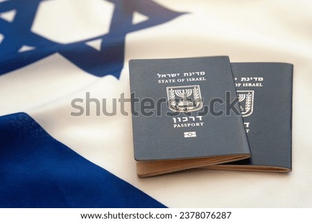 Two Israeli international passports lie on the Israeli flag with solar flare. Israeli citizenship concept Royalty-Free Stock Photo #2378076287