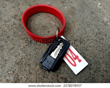 locker key along with bracelet and locker number, abstract floor background