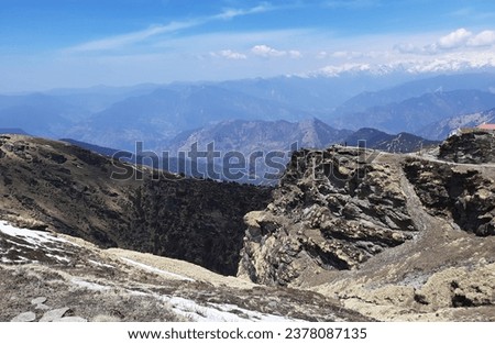 Collective view of rocky edge, mountain range and blue sky. Captured during trek to Chandrashila peak near Chopta village in Kedarnath wildlife sanctuary, Rudraprayag, Uttarakhand,India