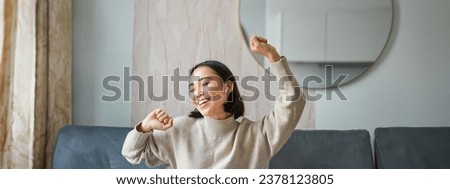 Close up portrait of beautiful asian girl dancing, feeling happy and upbeat, listening music in wireless headphones.