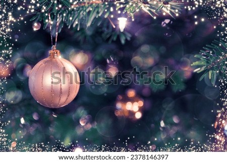 Christmas tree branch with golden ball and blur background.