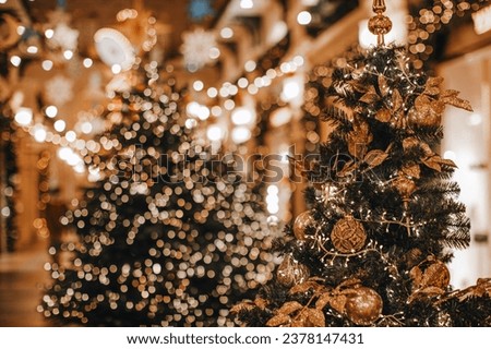 Golden Christmas trees decorated with festive miracle garlands bokeh lights. Magic interior in winter season. New Year holiday