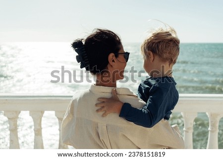 
The mother holds her son in her arms against the backdrop of th