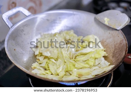 the cabbage is cooked in a wok.