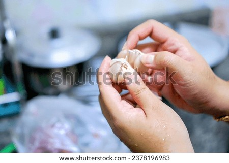 hands of a woman holding garlic.