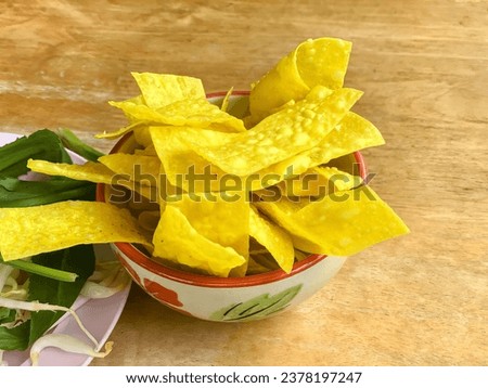 a bowl of nachos with a bunch of green leaves.