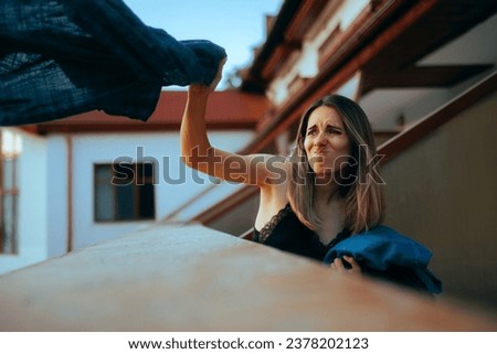 
Furious Girlfriend Throwing Boyfriend Clothes Over the Balcony. Angry woman feeling vindictive after her husband betrayed her 
 Royalty-Free Stock Photo #2378202123
