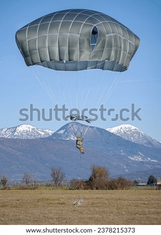 A U.S. Army paratrooper assigned to the 173rd Airborne Brigade prepares to land by pulling the risers on their T-11 parachute during a proficiency jump over Juliet Drop Zone near Pordenone, Italy  Royalty-Free Stock Photo #2378215373