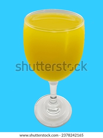 Photograph of fruit juice in a clear glass, colored background
