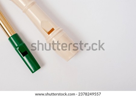 Irish whistle and block flute are longitudinal flutes with a whistle device and playing holes. Royalty-Free Stock Photo #2378249557