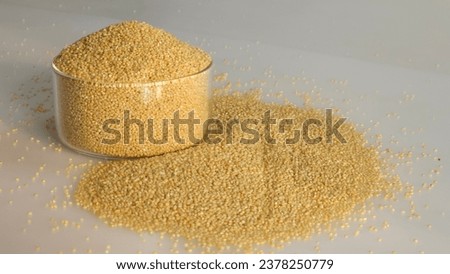 Closeup of foxtail millet grains in a glass bowl filled to the brim, highlighting their organic texture and natural golden hue. It is the second most widely grown millet in Indi Royalty-Free Stock Photo #2378250779