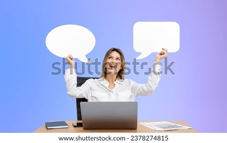 Portrait of cheerful young businesswoman sitting with laptop at office table and holding two mock up speech bubbles over purple background. Concept of communication and choice