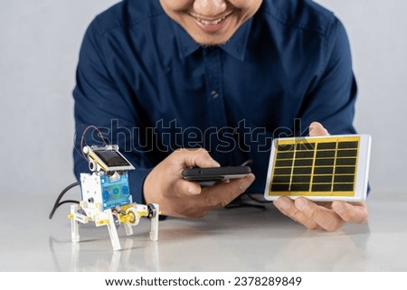 Students build a solar powered robot in their home office by controlling it via smartphone. DIY solar powered robot on a table at home, science experiment concept.