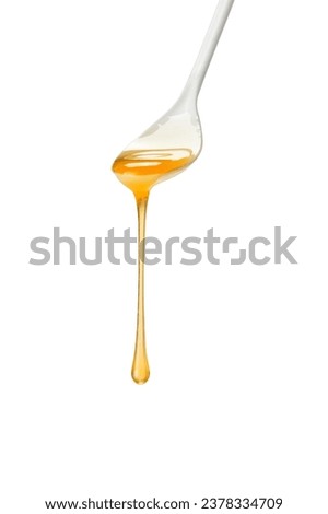 honey dripping from a spoon on a white background Royalty-Free Stock Photo #2378334709