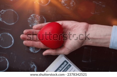 Red heart in the palm of your hand against the background of a medical card. cardiology concept