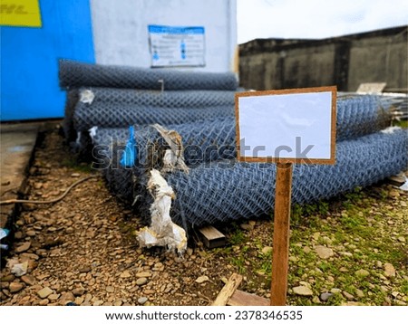 close up stack of chain link fence rolls in warehouse outdoors on ground without wooden pallets