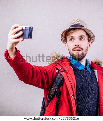 Young tourist taking a picture with camera