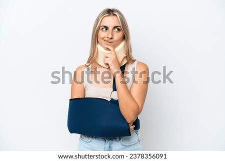 Woman with broken arm and wearing a sling isolated on white background having doubts and thinking Royalty-Free Stock Photo #2378356091