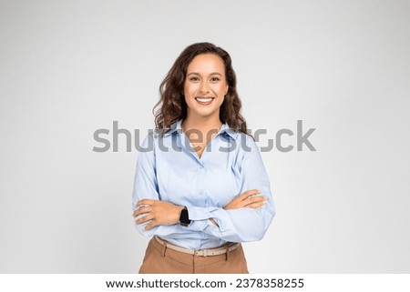 Smiling confident calm millennial european business woman, teacher in formal wear with crossed arms, isolated on gray background studio background. Work, education, ad and offer Royalty-Free Stock Photo #2378358255