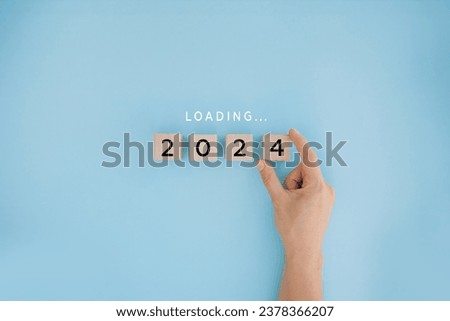 Female hand putting wooden cube for countdown to 2023. Loading year from 2023 to 2024. New year start concept