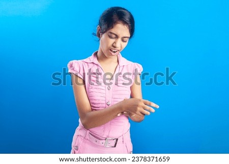 wrist inflammation, body pain, bone fracture. Indian girl clutching her wrist injury with shouting expression