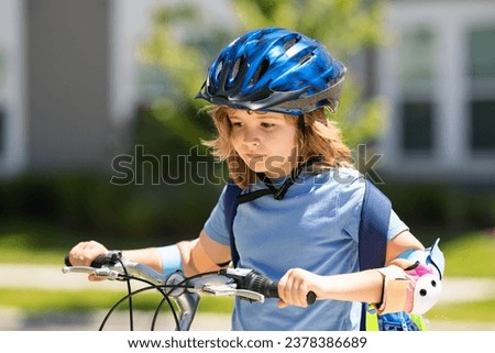 Kid riding bike in a helmet. Child riding bike in protective helmet. Safety kids sports and activity. Happy kid boy riding bike in summer park. Bike helmet, bicycle safety, cycling accessories.